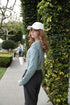 Side view of the Long Sleeve Cable Knit Crop Sweater showing cropped length and cable sleeves