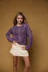 Model wearing the Long Sleeve Cable Knit Crop Sweater in plum with a cream skirt